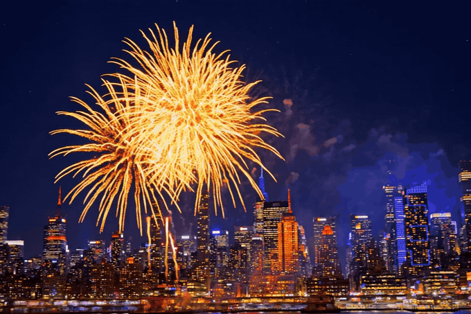 Happy New Year 2027 fireworks GIF — golden 3D Happy New Year 2027 text over golden fireworks and a city skyline at midnight